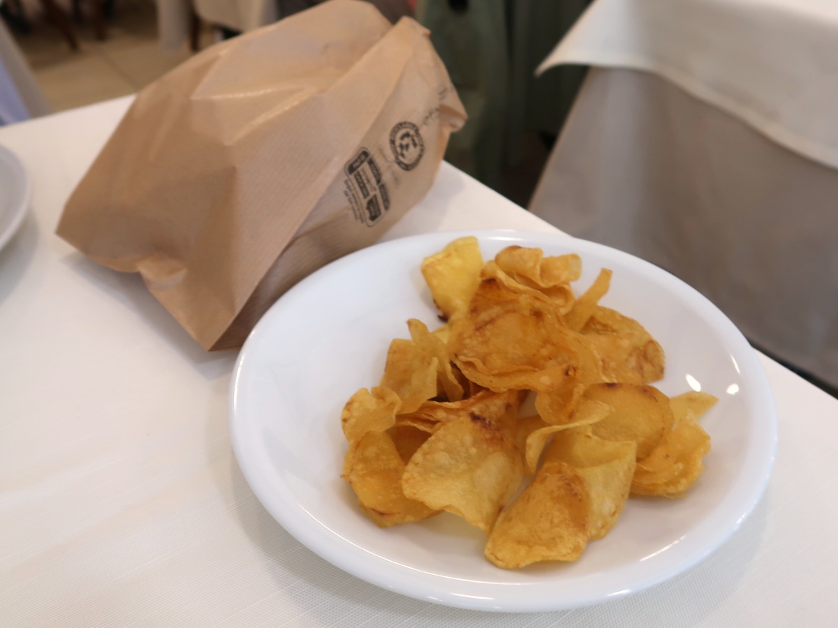 紙袋入りのパンとポテトチップス